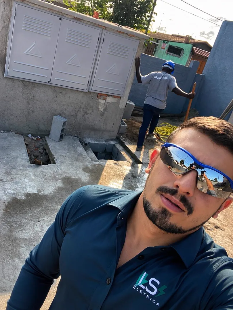 Leandro em obra, ao lado do padrão de entrada recém-instalado